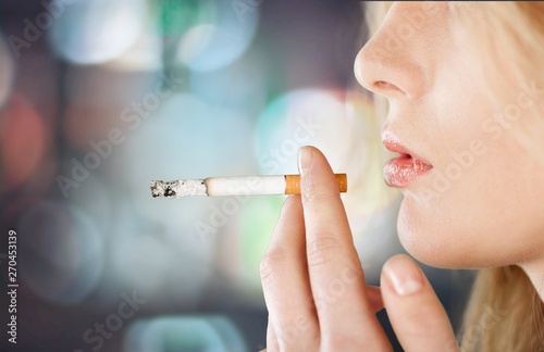 Portrait of the young elegant girl smoking cigarette isolated