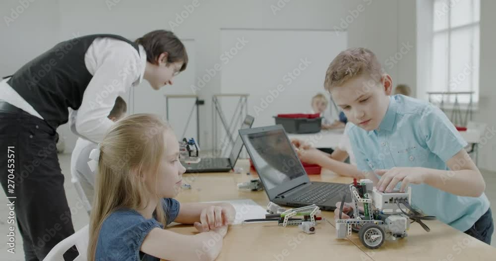 Curious kids working on a functional programable robot during robotics class at school. 4K UHD 60 FPS SLOW MOTION