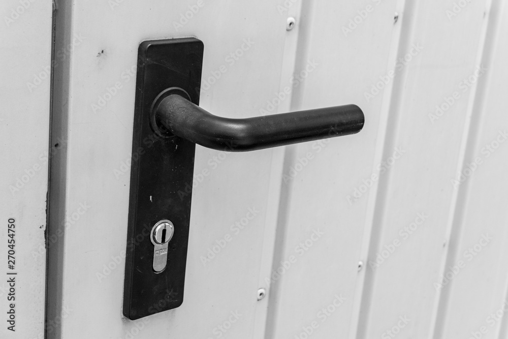 black door handle with lock at a door to the garage made of sheet metal black door handle with lock at a door to the garage made of sheet metal