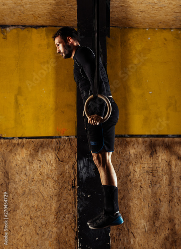 Shot of a young man working out on the rings in the gym © qunica.com