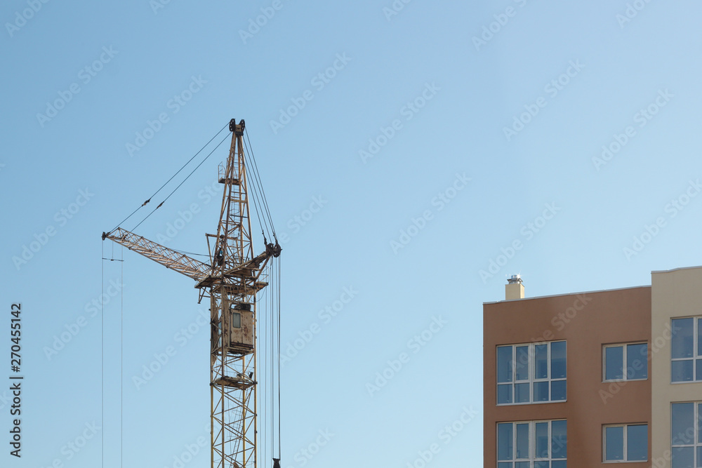 Industrial construction building crane against blue sky Industrial construction building crane against blue sky