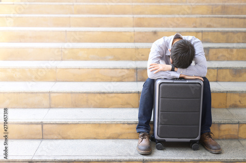  The young man was tired and stressed on the suitcase due to the plane crash