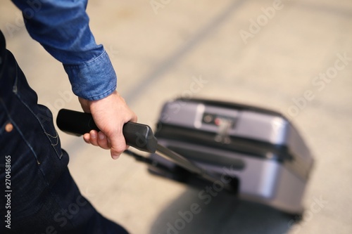 A young businessman dragged the bag to travel on a plane to travel.