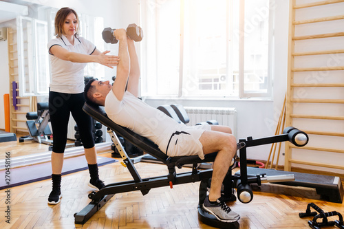Fototapeta Naklejka Na Ścianę i Meble -  Man workout at the gym  with a personal trainer