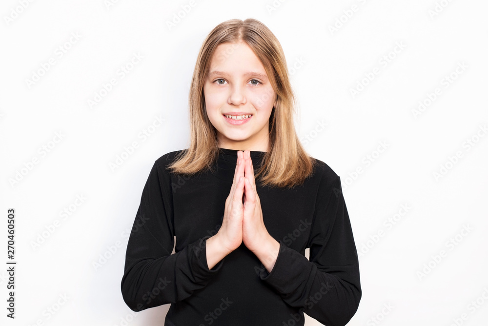 Beautiful young girl on a light background smiling and praying for parents, she loves them very much Beautiful young girl on a light background smiling and praying for parents, she loves them very much