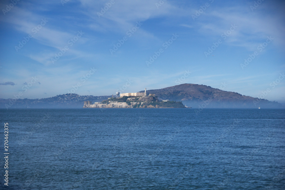 SAN FRANCISCO, CALIFORNIA, UNITED STATES - NOV 25th, 2018: Alcatraz prison in fog panorama during a sunny day in November as seen from pier 39 SAN FRANCISCO, CALIFORNIA, UNITED STATES - NOV 25th, 2018: Alcatraz prison in fog panorama during a sunny day in November as seen from pier 39