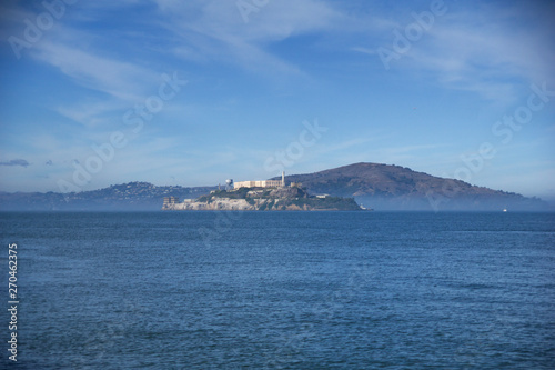 SAN FRANCISCO, CALIFORNIA, UNITED STATES - NOV 25th, 2018: Alcatraz prison in fog panorama during a sunny day in November as seen from pier 39