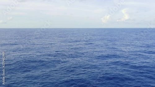 ship view of the open endless blue ocean, calm sea, with the sky above the horizon