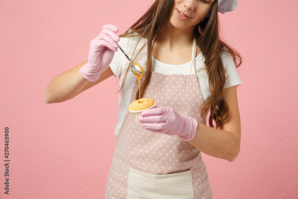 Cute housewife chef cook confectioner baker in white t-shirt, toque chefs hat cooking hold sweet isolated on pink pastel background in studio. Cupcake making process. Mock up copy space food concept. Cute housewife chef cook confectioner baker in white t-shirt, toque chefs hat cooking hold sweet isolated on pink pastel background in studio. Cupcake making process. Mock up copy space food concept.