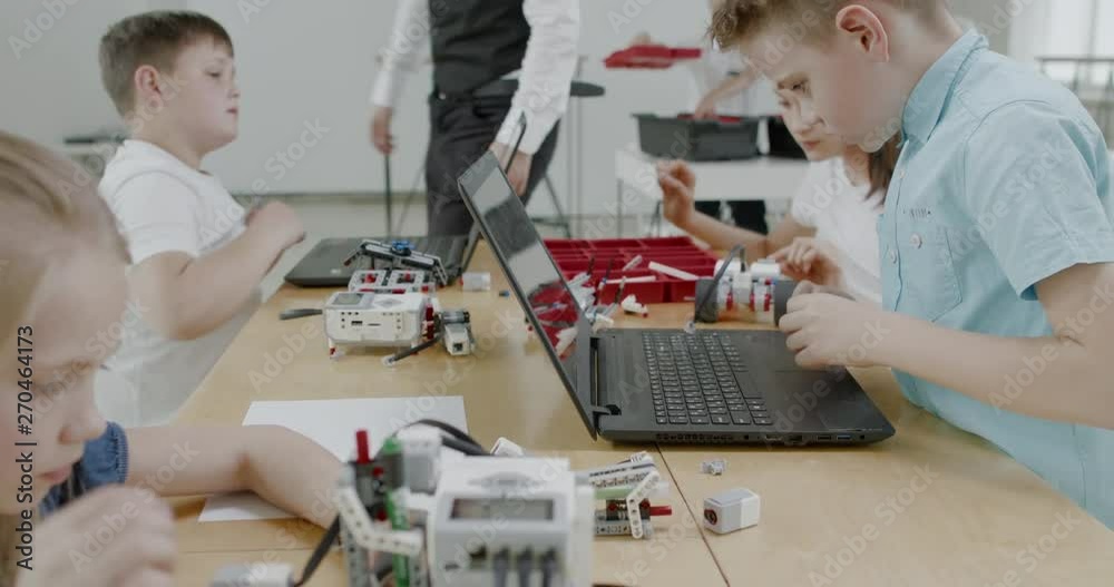 Curious kids working on a functional programable robot during robotics class at school. 4K UHD 60 FPS SLOW MOTION