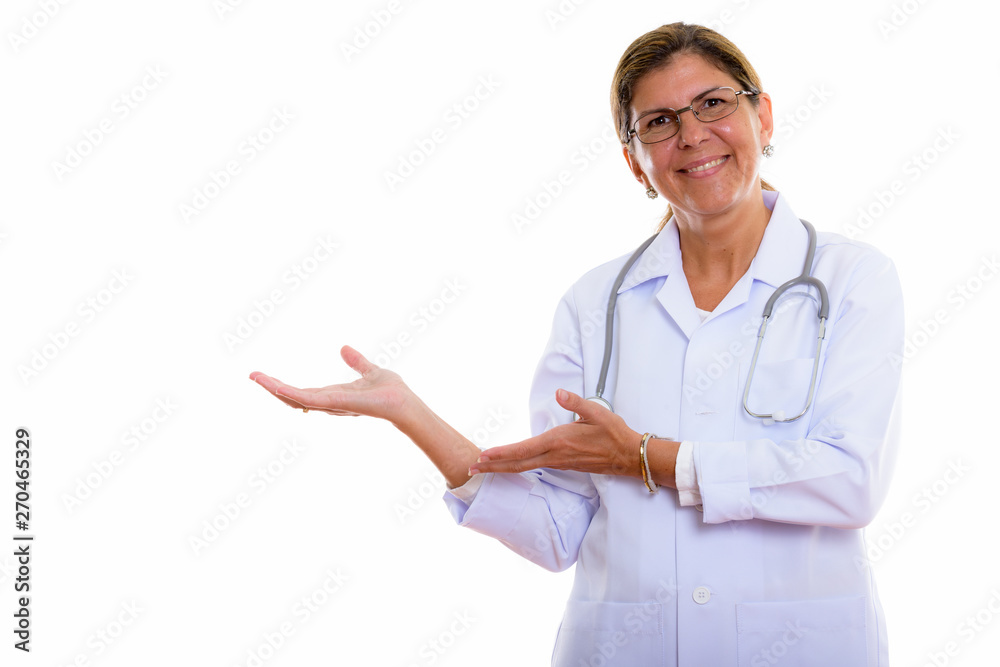Studio shot of mature happy woman doctor smiling and showing som Studio shot of mature happy woman doctor smiling and showing som