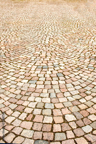 A fragment of the sidewalk  lined with colored granite stone in the town square.  Texture  background.