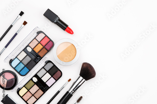 Set of makeup cosmetic: shadows, brushes, lipstick on a white background, top view, text space