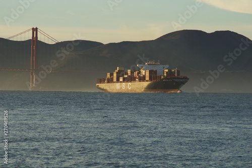 SAN FRANCISCO, CALIFORNIA, UNITED STATES - NOV 25th, 2018: MSC Cargo Ship SILVIA entering the San Francisco Bay under the Golden Gate Bridge on its way to the Port of Oakland - a fully loaded photo