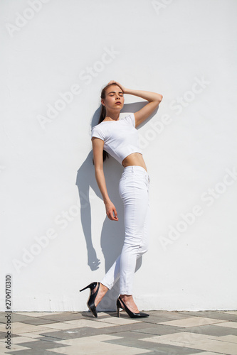 Model tests. Young beautiful brunette model posing against a white wall
