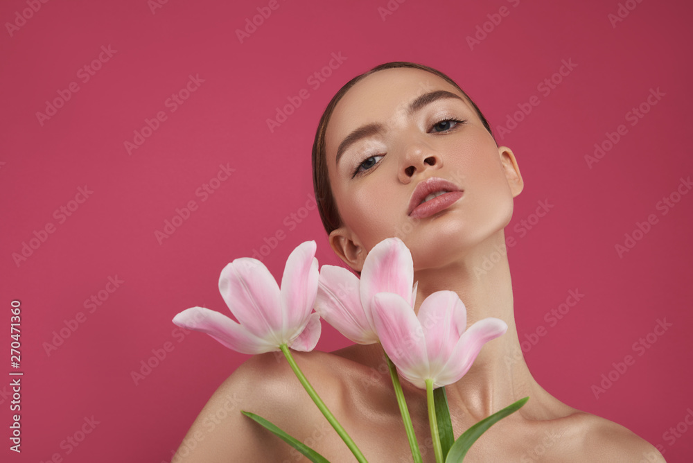 Beautiful young woman with perfect skin holding tulips Beautiful young woman with perfect skin holding tulips