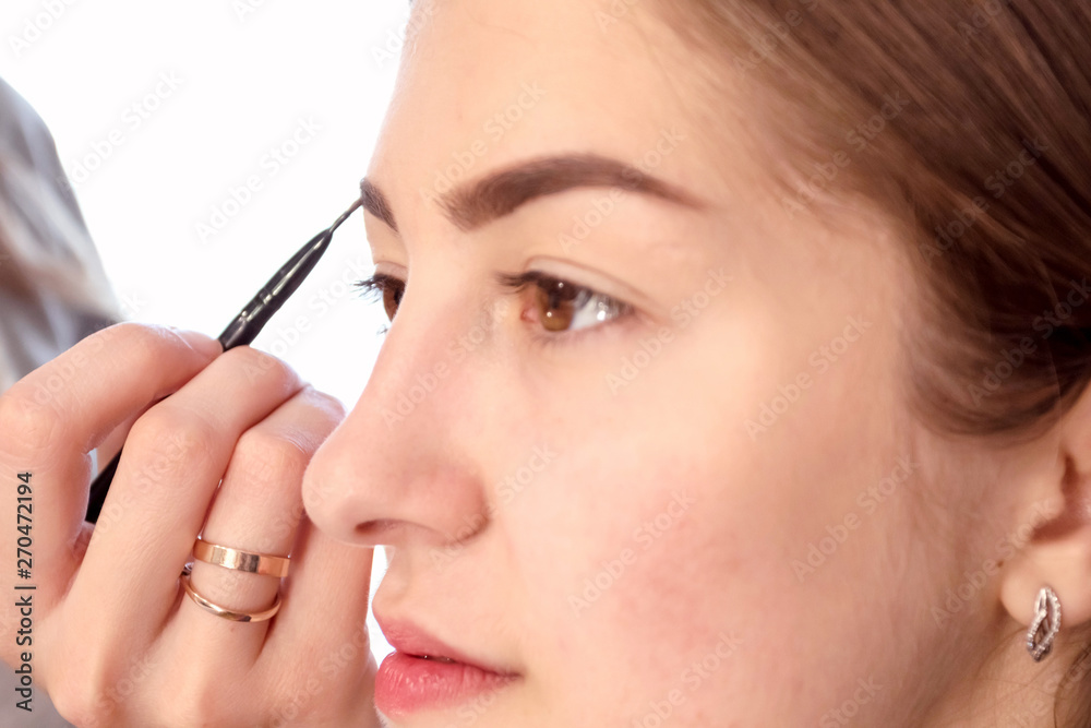 Make-up artist painting beautiful girl eyeshadows. Make-up artist painting beautiful girl eyeshadows.
