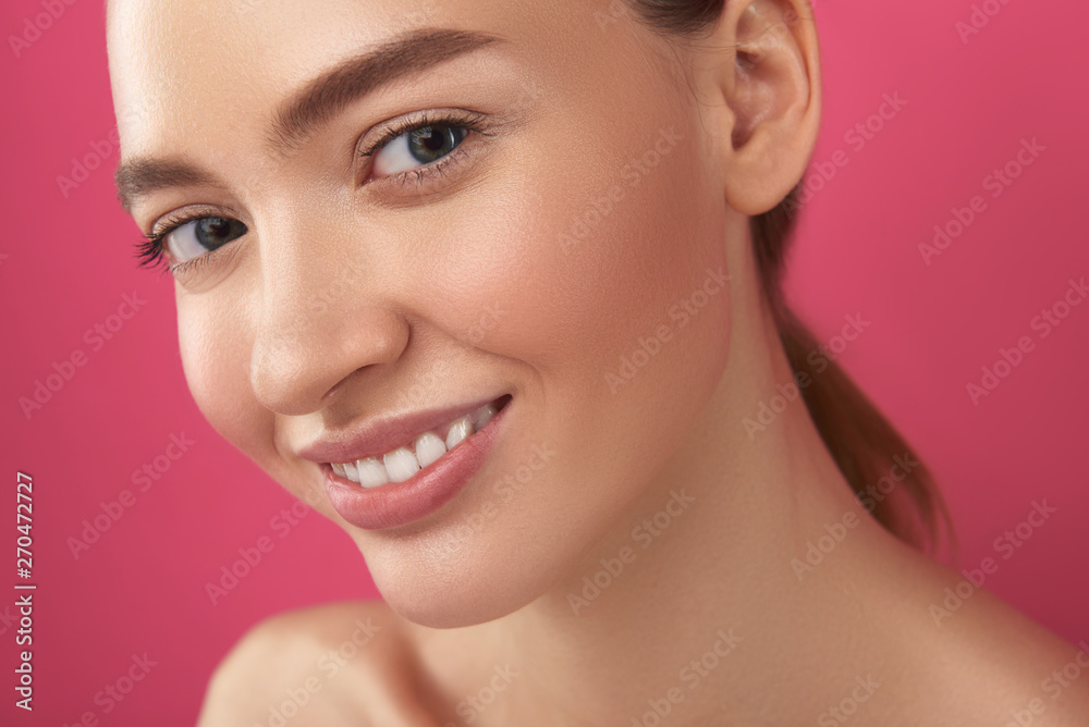 Joyful girl with perfect skin standing against pink background Joyful girl with perfect skin standing against pink background