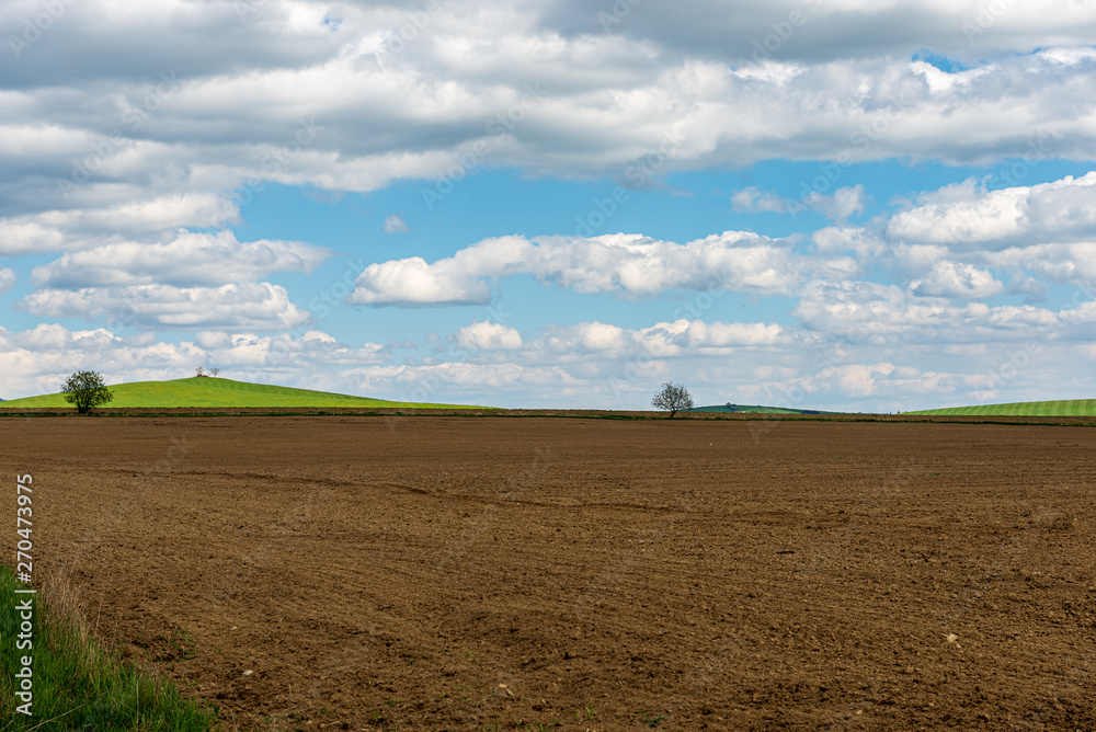 cultivated fields in countryside with dark and wet soil for agriculture.