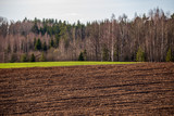 cultivated fields in countryside with dark and wet soil for agriculture.
