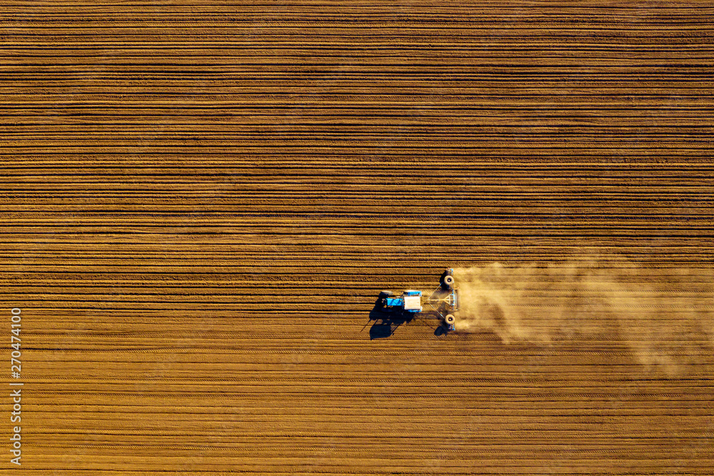Tractor in field on a farm, aerial view Tractor in field on a farm, aerial view