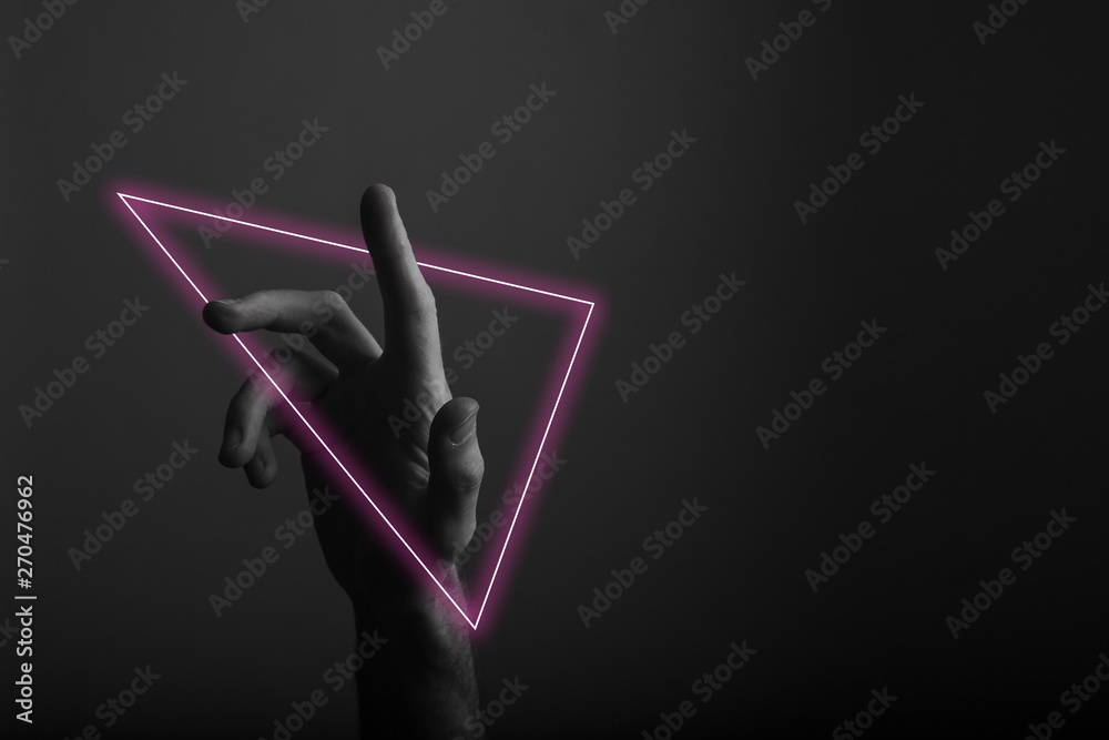 Foto de Hand pointing a finger against a dark background with abstract ...