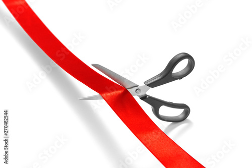 Scissors cutting red ribbon or tape against white background -Clipping Path