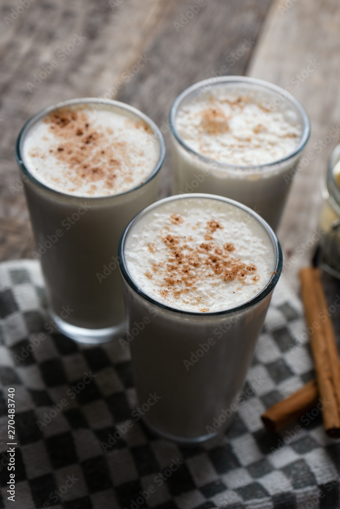 Banana smothie or milkshake with cinnamon on wood background Banana smothie or milkshake with cinnamon on wood background