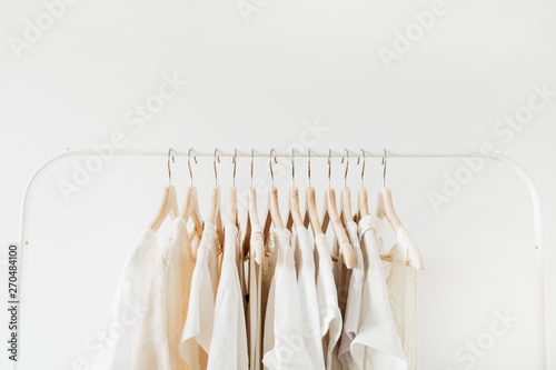 Minimal fashion clothes concept. Female blouses and t-shirts on hanger on white background. Fashion blog, website, social media hero header.