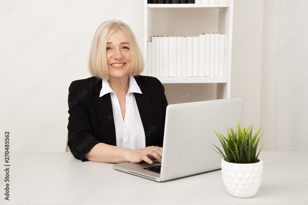 Office woman typing at her laptop at her workplace Office woman typing at her laptop at her workplace