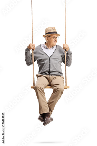 Mature gentleman sitting on a swing and looking to the side