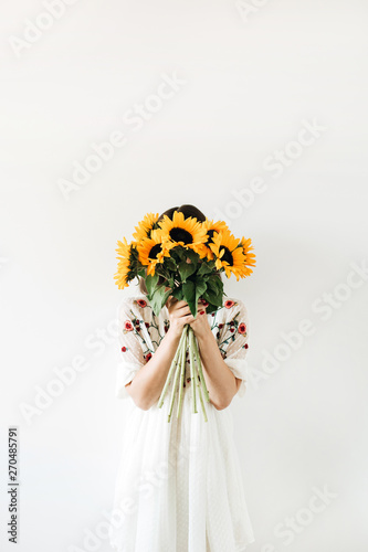 Young pretty woman with sunflowers bouquet on white background.