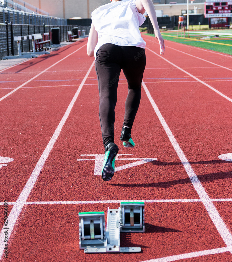 Sprinter racing down the track from behind the blocks Sprinter racing down the track from behind the blocks