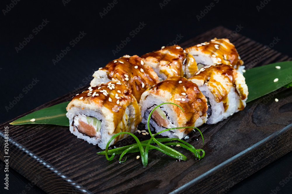 Japanese traditional rolls with seafood and fish, vegetables, on a black background. Japanese traditional rolls with seafood and fish, vegetables, on a black background.