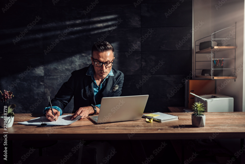 Businessman writing project report in his office