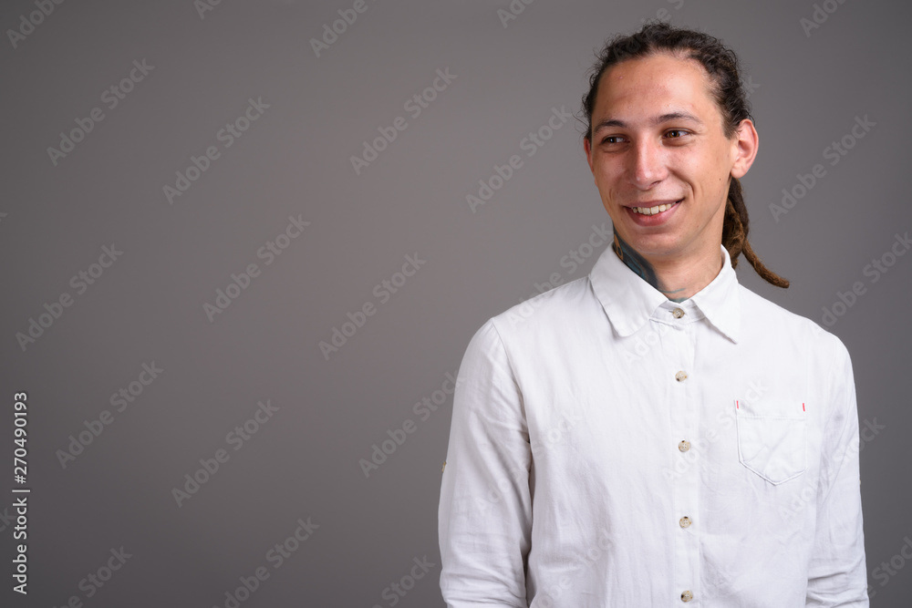Young businessman with dreadlocks against gray background Young businessman with dreadlocks against gray background
