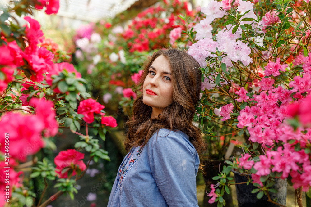 portrait of a young beautiful woman in a blue dress in a beautiful botanic garden with flowers portrait of a young beautiful woman in a blue dress in a beautiful botanic garden with flowers