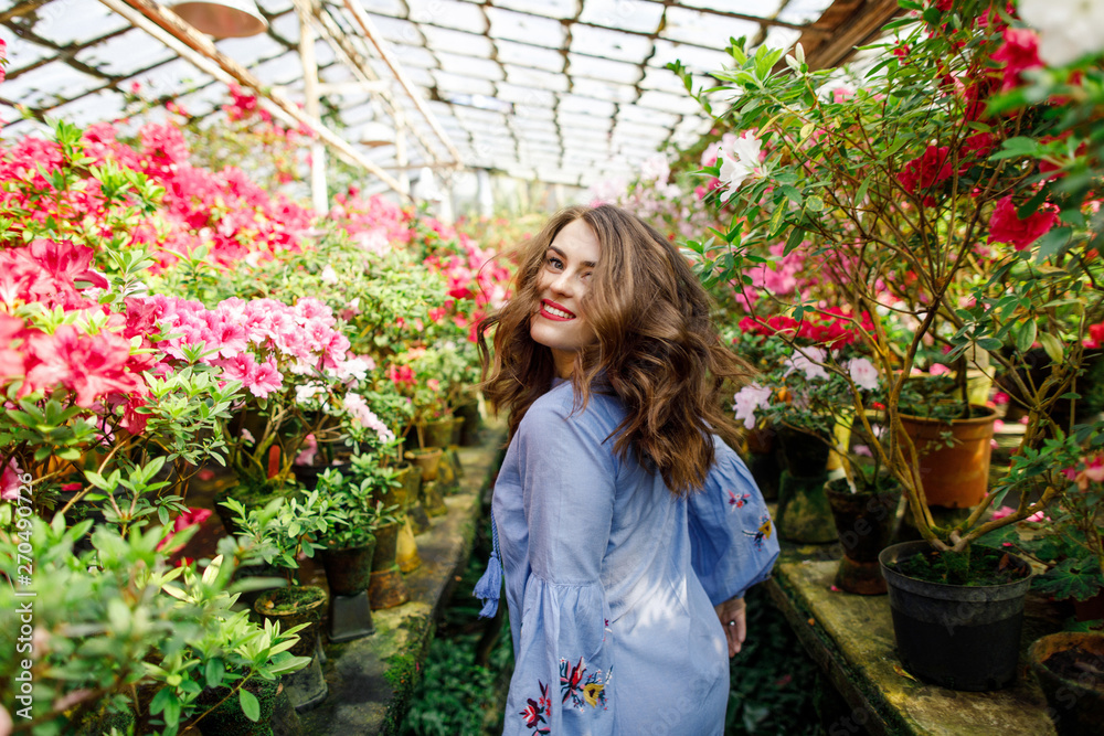 portrait of a young beautiful woman in a blue dress in a beautiful botanic garden with flowers portrait of a young beautiful woman in a blue dress in a beautiful botanic garden with flowers
