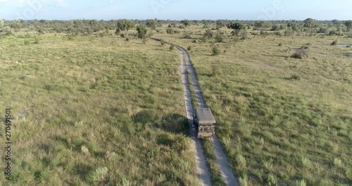 Aerial view of a safari vehicle driving through the bush of the Okavango Delta photo