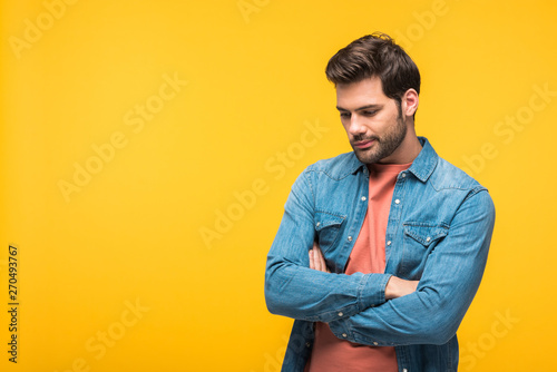 handsome pensive man with crossed arms Isolated On yellow © LIGHTFIELD STUDIOS