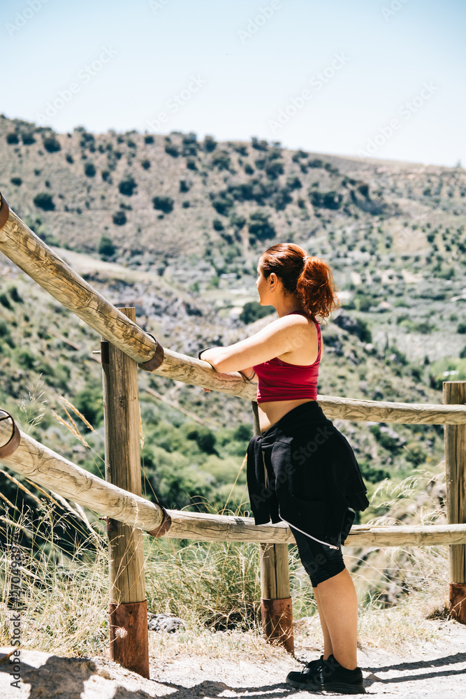 Naklejka premium Happy young woman hiker watching the landscape