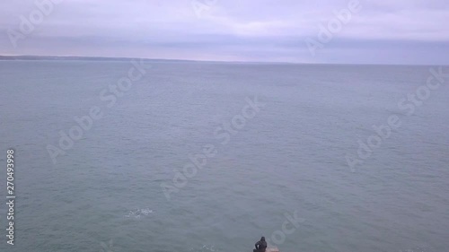 Aerial drone view video in motion of skyline in the Atlantic Ocean nea the Fort of Peniche, Portugal. Stone beach. Fisherman catches fish. photo