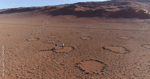 Aerial view of a tourist and guide exploring the famous fairy circles in the NamibRand Nature Reserve