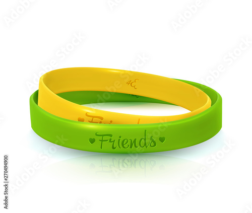 Friendship Day background, happy holiday of amity. Two rubber bracelets for best friends: yellow and green. Silicone wristbands on white background