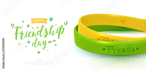 Friendship Day background, happy holiday of amity. Two rubber bracelets for best friends: yellow and green. Silicone wristbands and inscription of congratulations on white background