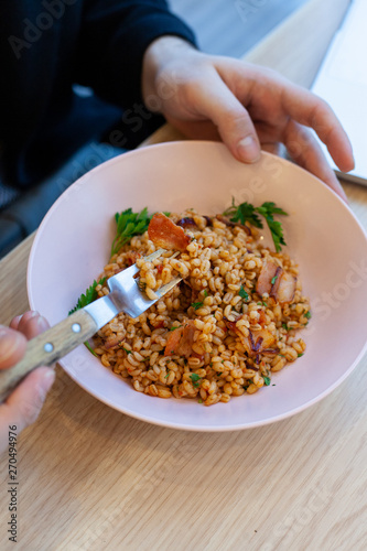 Wallpaper Mural Man is having pearl barley with grilled bacon and sweet'n'sour sause for lunch in a cafe Torontodigital.ca