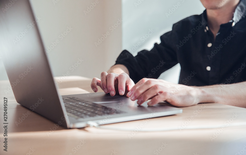 Man hands working with black laptop in office Man hands working with black laptop in office