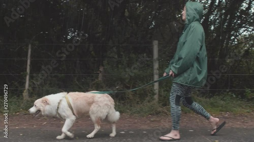 Woman walking her dog in the rain
