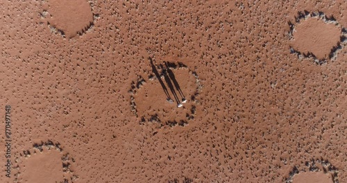Aerial view of a tourists and guide exploring the famous fairy circles in the NamibRand Nature Reserve