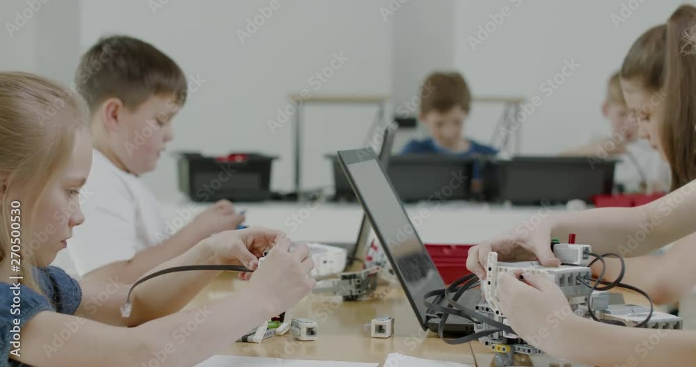 Curious kids working on a functional programable robot during robotics class at school. 4K UHD 60 FPS SLOW MOTION Curious kids working on a functional programable robot during robotics class at school. 4K UHD 60 FPS SLOW MOTION